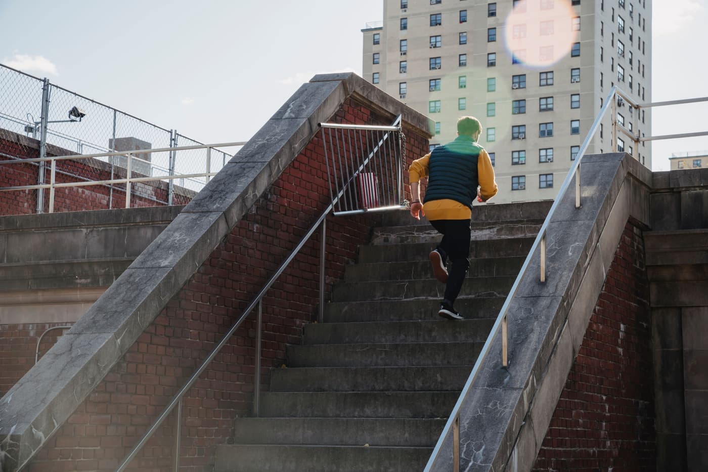 A person training outdoors, running up a stairway on a residential street