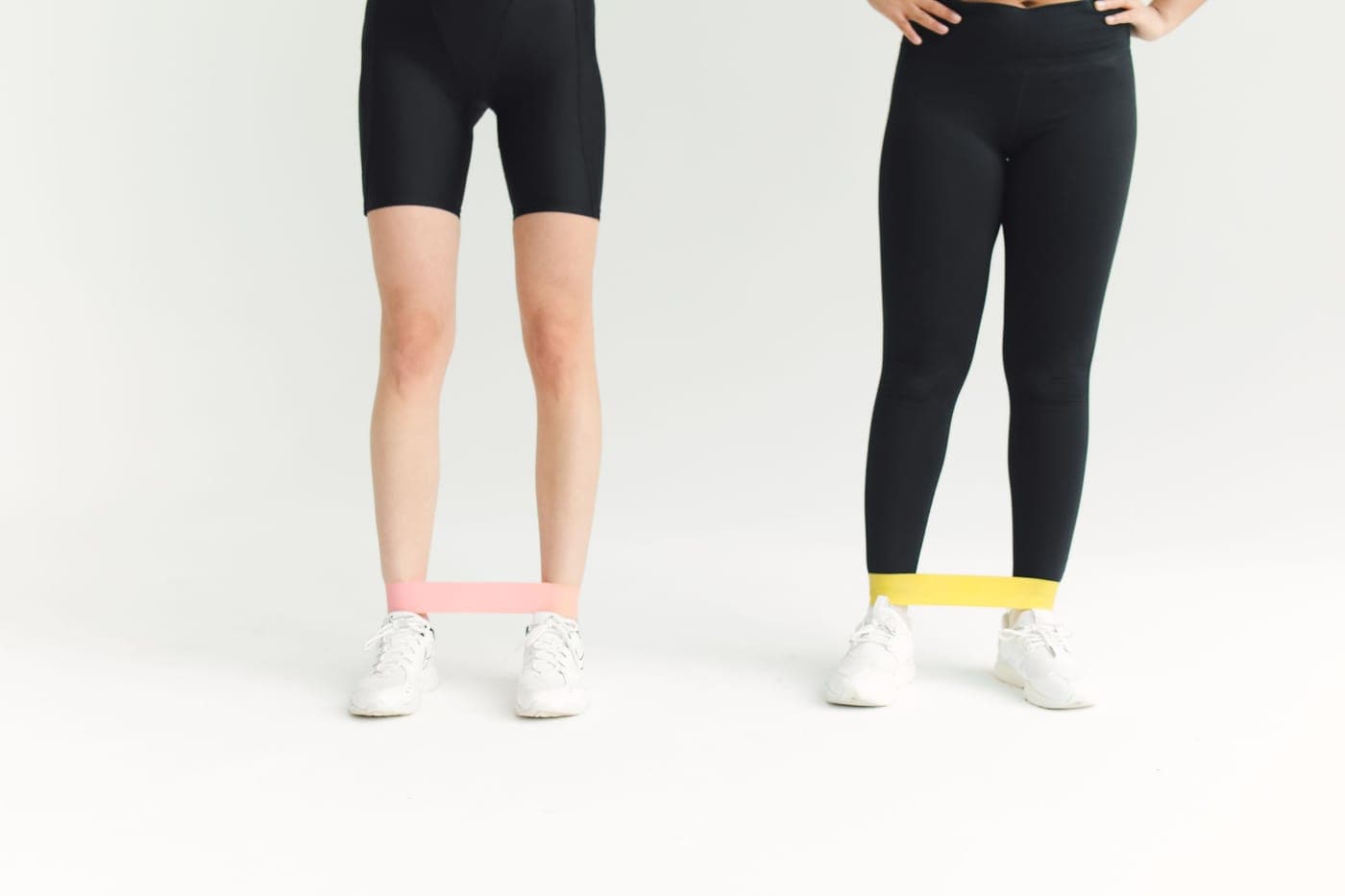Two people in activewear using resistance bands during an indoor workout session