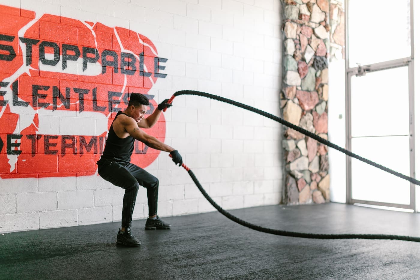 A man training with battle ropes in a gym