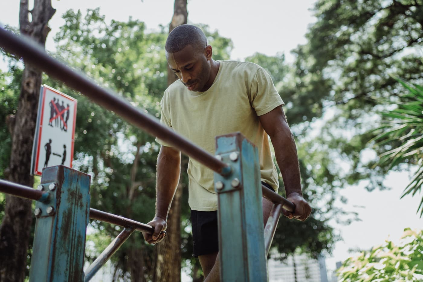 A man performing a dip on parallel bars outdoors