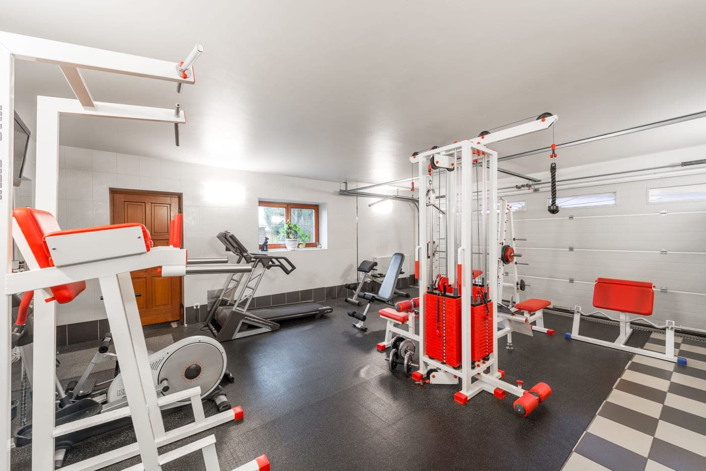 A spacious home gym in a basement with training equipment