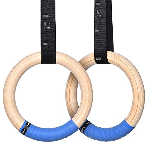 Wooden gymnastic rings hanging in a dimly lit gym